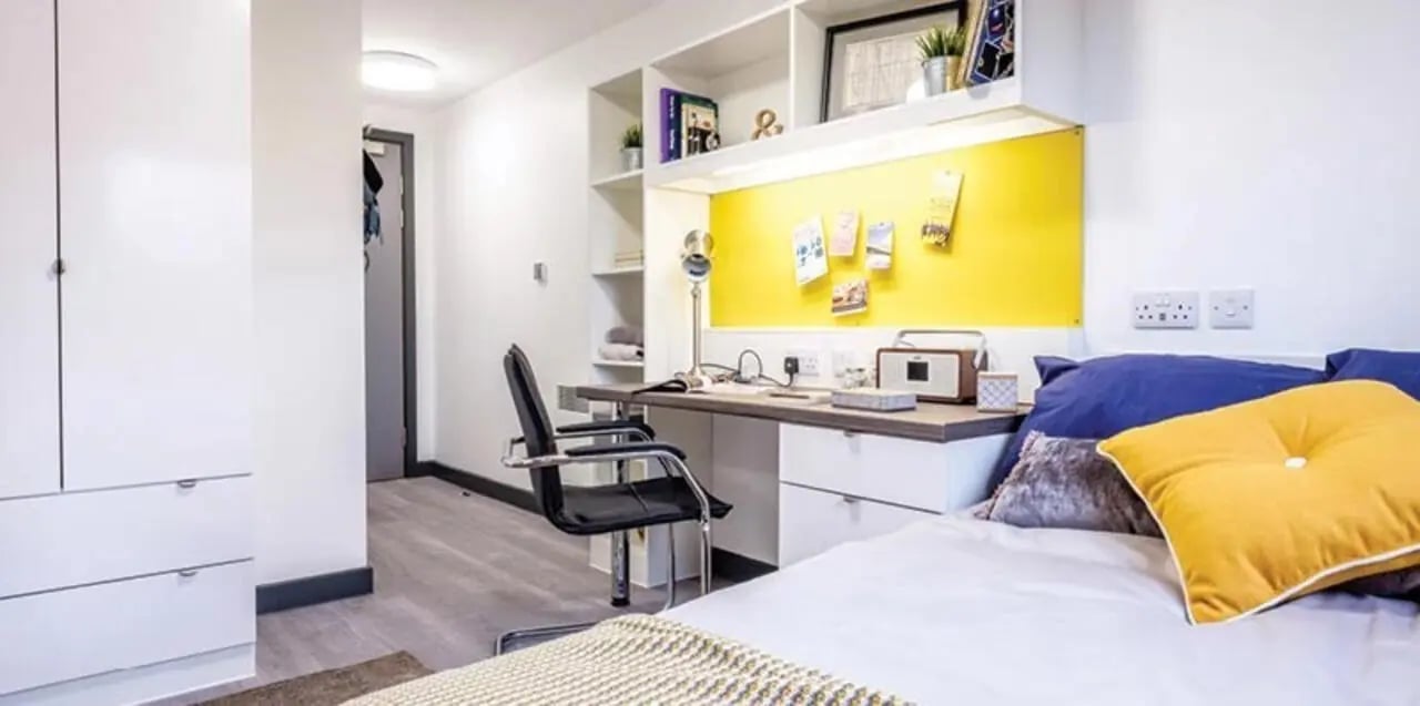 Desk chair bed with yellow pillow study area bedroom at Albert Place in Newcastle Upon Tyne Student Accommodation
