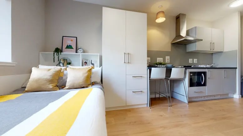 Bed wardrobe kitchen with bar stools studio apartment at Centro House in Stirling Student Accommodation