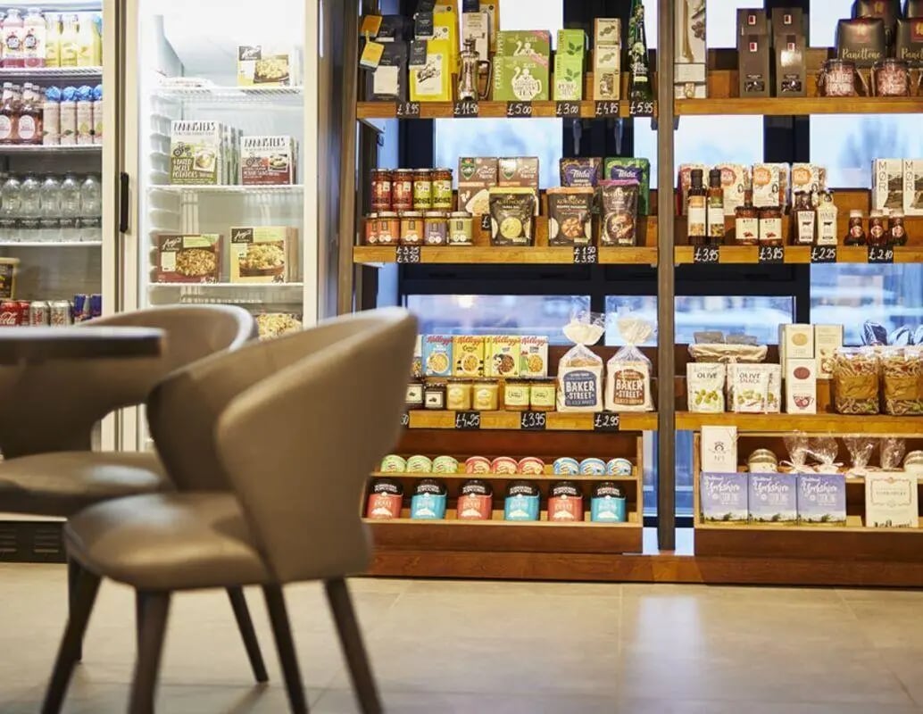 Chairs and shelves stocked with food items common area at IconInc York City in York Student Accommodation