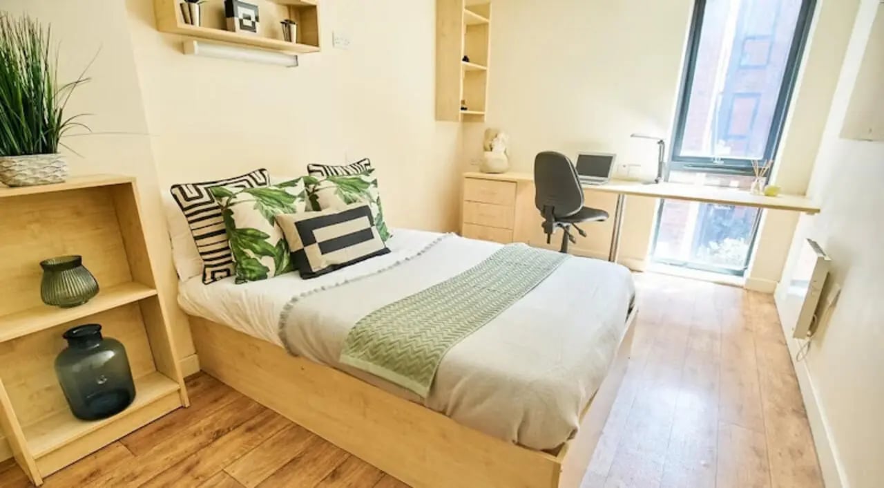 Bed desk plant pillows bookshelf bedroom at Rockingham House in Sheffield Student Accommodation
