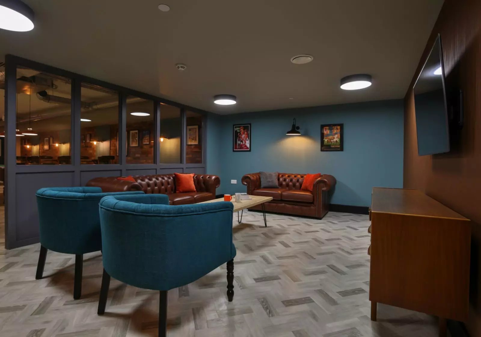 Two teal chairs two leather sofas living room at iQ Studios 51 in Birmingham Student Accommodation