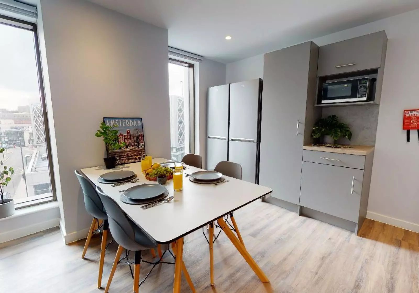 Table chairs refrigerator microwave kitchen area at iQ Altus House in Leeds Student Accommodation