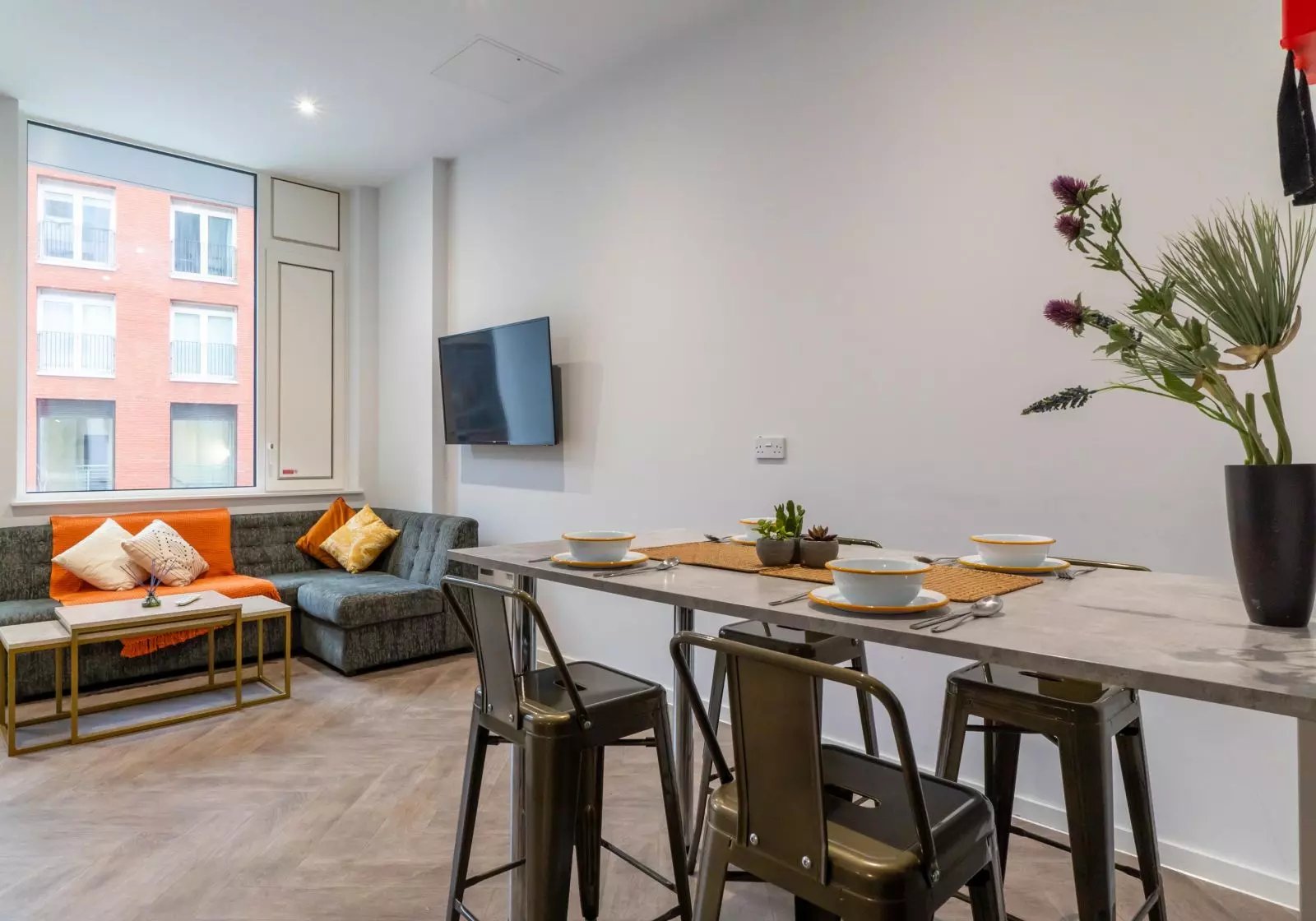Sofa television dining table and stools living room at iQ Vega London in London Student Accommodation