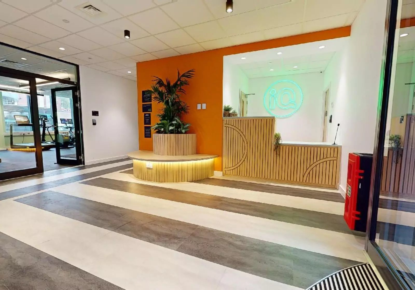 Reception desk with plants and gym entrance lobby at iQ Nelson Court in Nottingham Student Accommodation