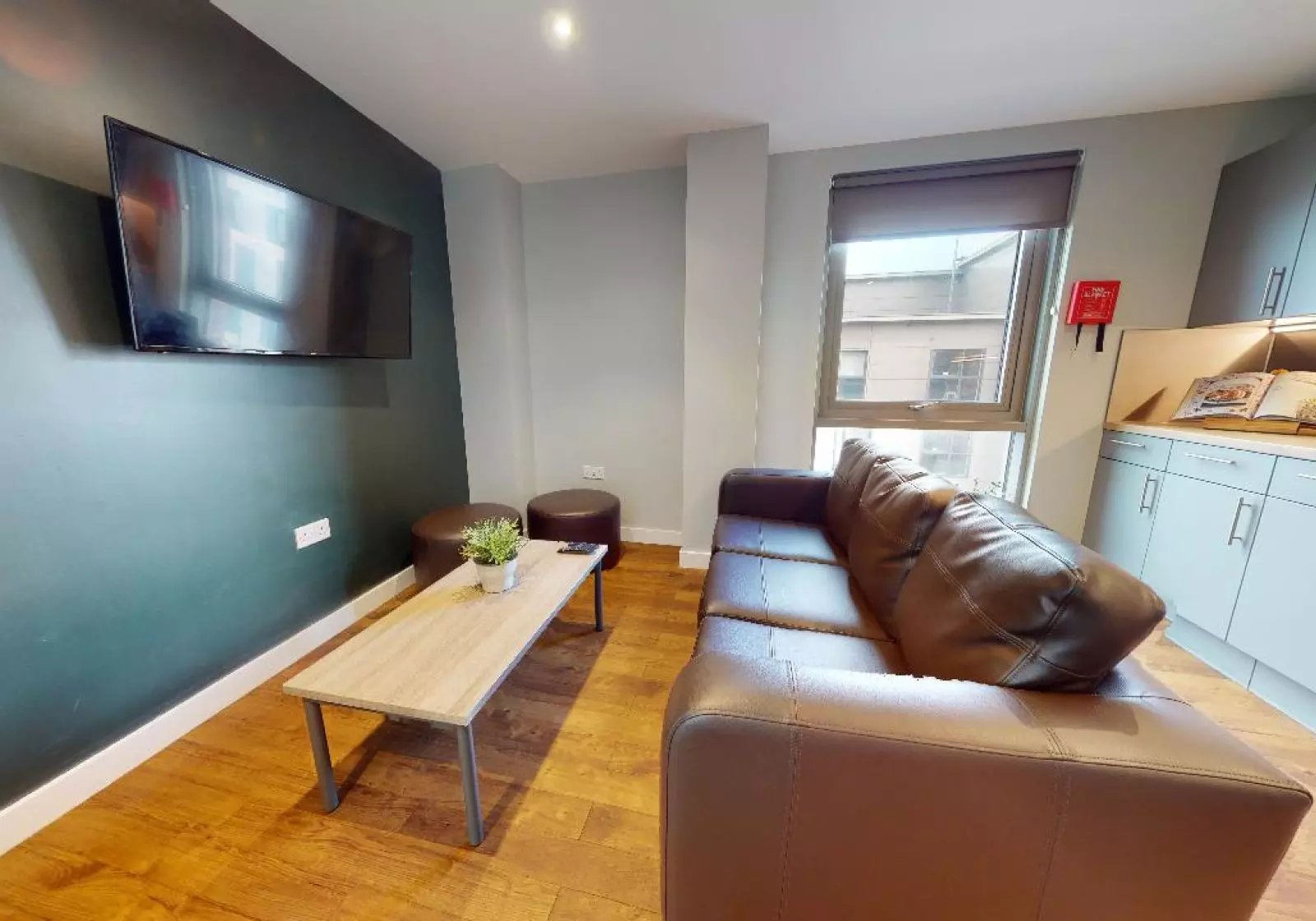 Brown sofa coffee table two ottomans television living room at iQ Knight House in Sheffield Student Accommodation