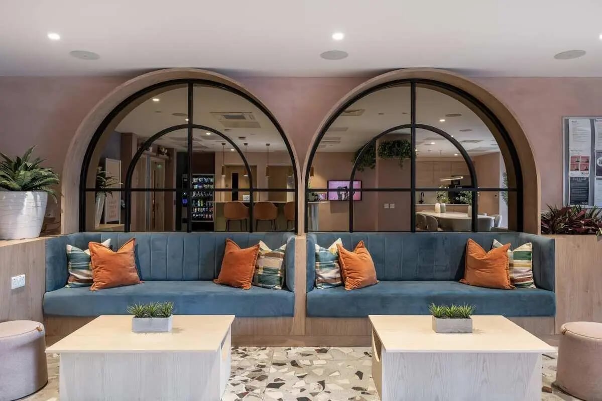 Blue sofas with orange cushions living room at Aster House in Belfast Student Accommodation