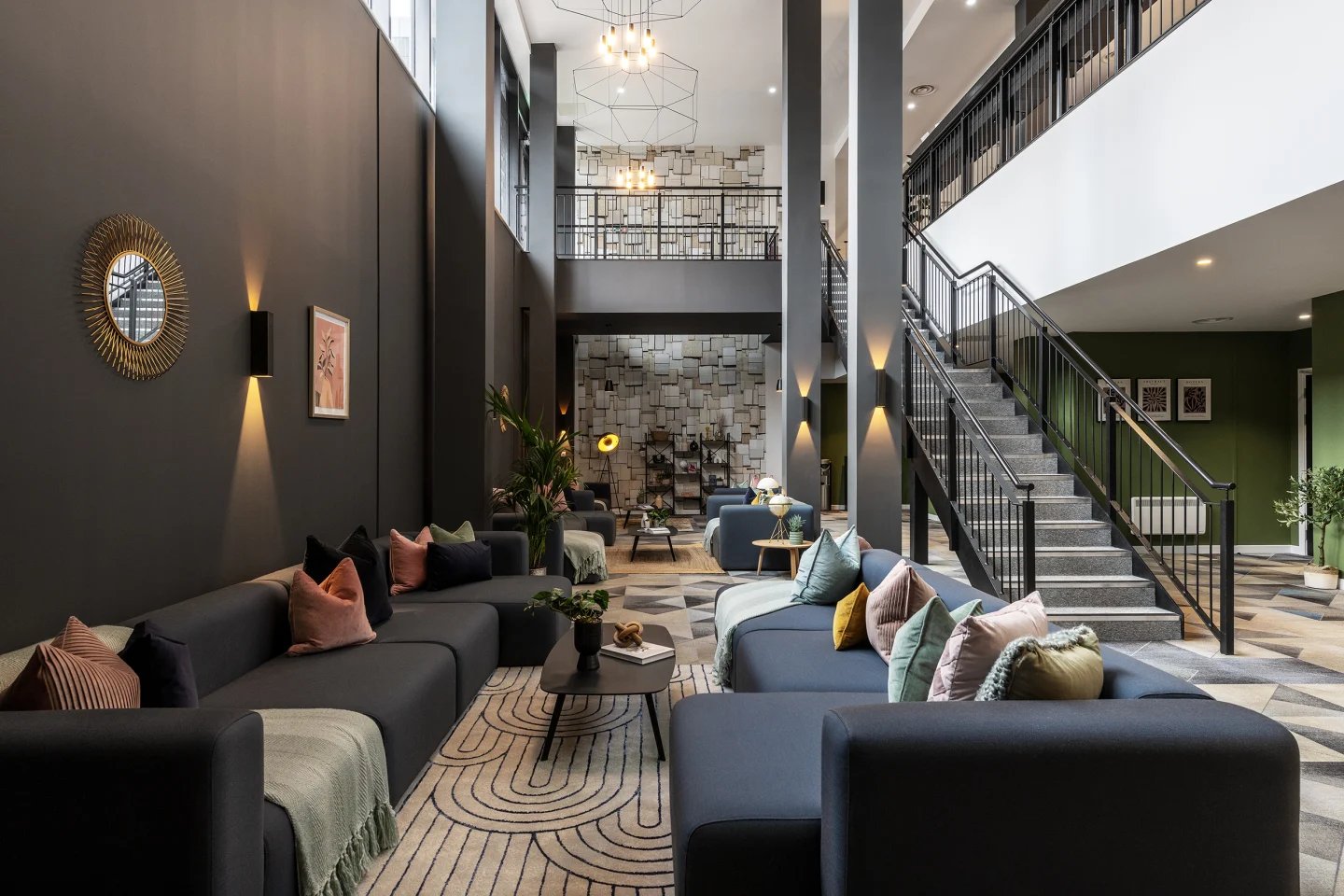 Modern lounge with modular sofas and stairs living room at Infinity Coventry in Coventry Student Accommodation