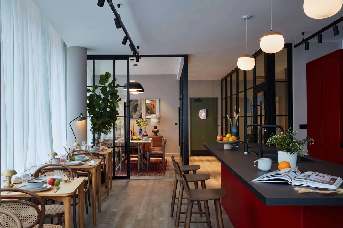 Dining tables kitchen island and bar stools living room at Tribu Kingston in Kingston Upon Thames Student Accommodation