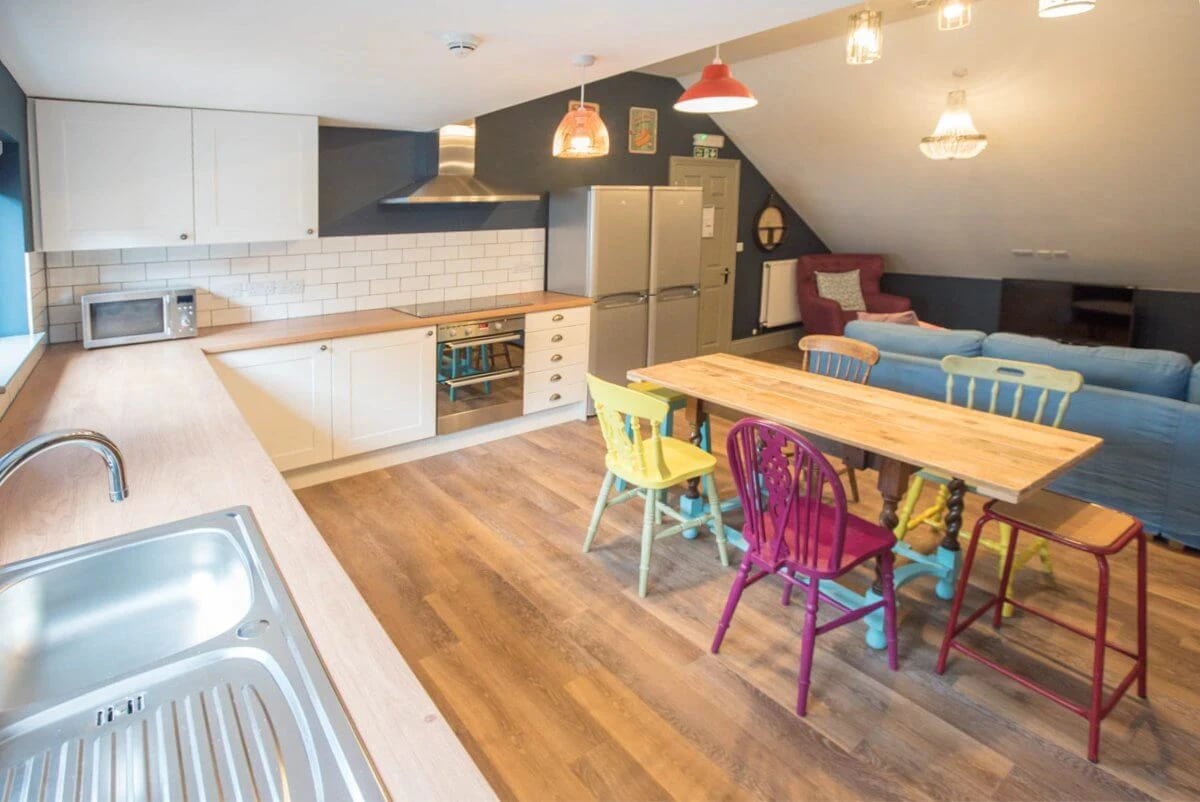 Kitchen with colorful chairs and sofa Living Room at Mary Morris House in Leeds Student Accommodation