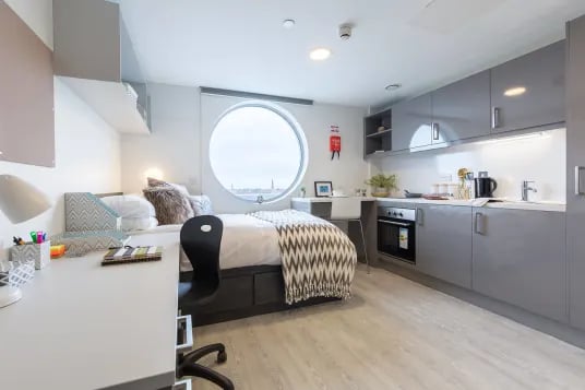 Bed desk kitchen area with modern cabinets and oven room at Livin Cardiff in Cardiff Student Accommodation