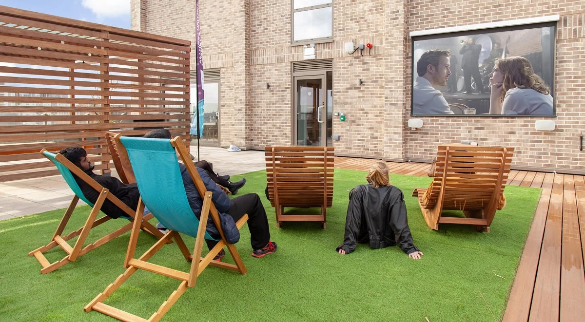 Rooftop outdoor cinema with lounge chairs playing area at Symons House in Leeds Student Accommodation