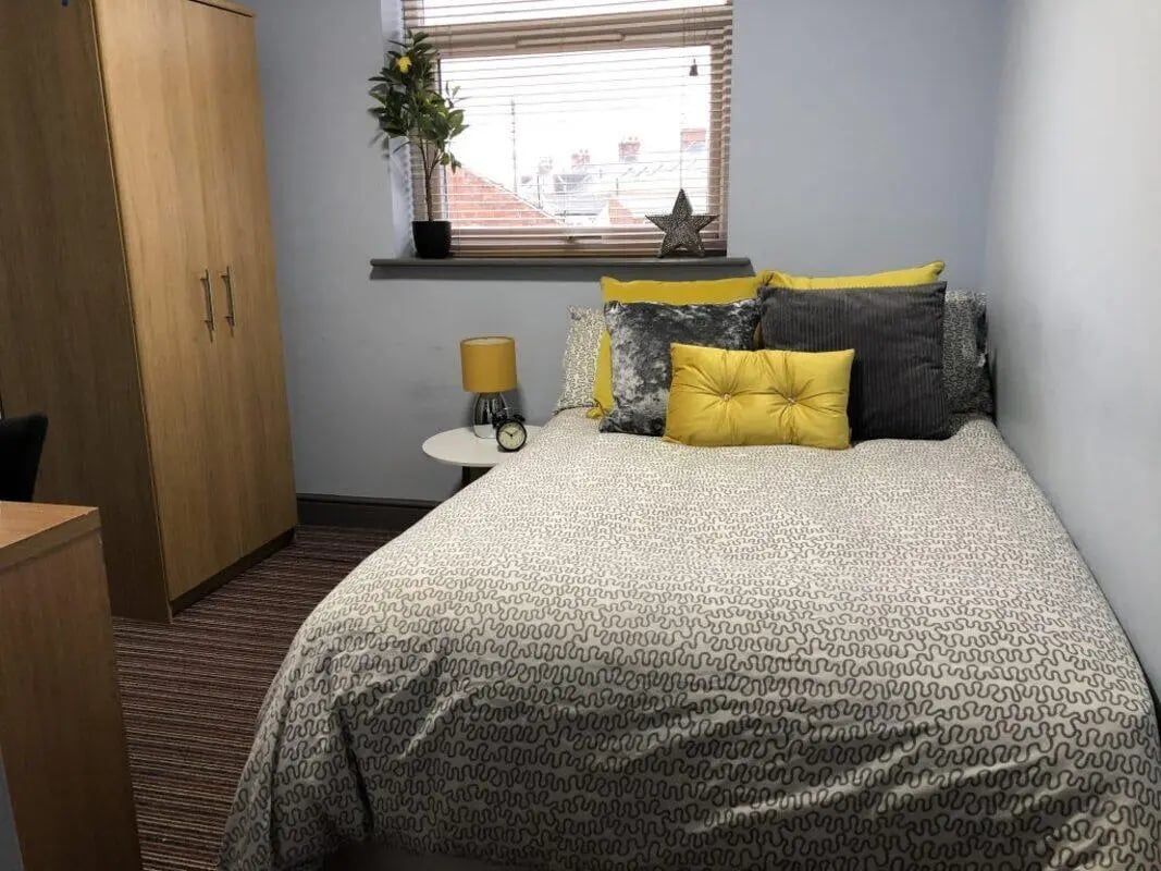 Wardrobe bed with yellow pillows and lamp bedroom at Millfield House in Sunderland Student Accommodation