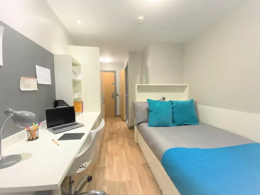 Desk bed pillows and shelving student accommodation bedroom at John Bell House in Belfast Student Accommodation