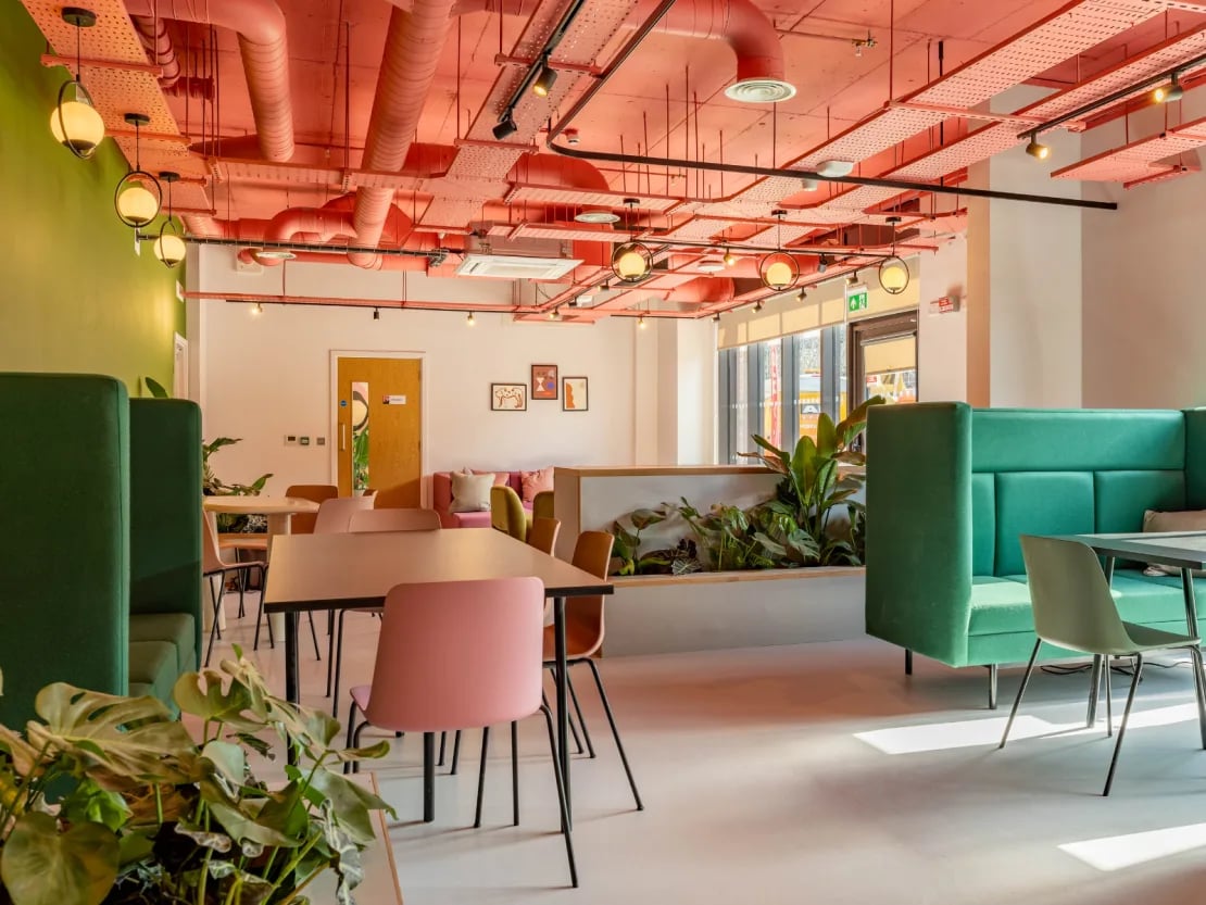 Green booths tables chairs plants common area at The Brook in Bath Student Accommodation