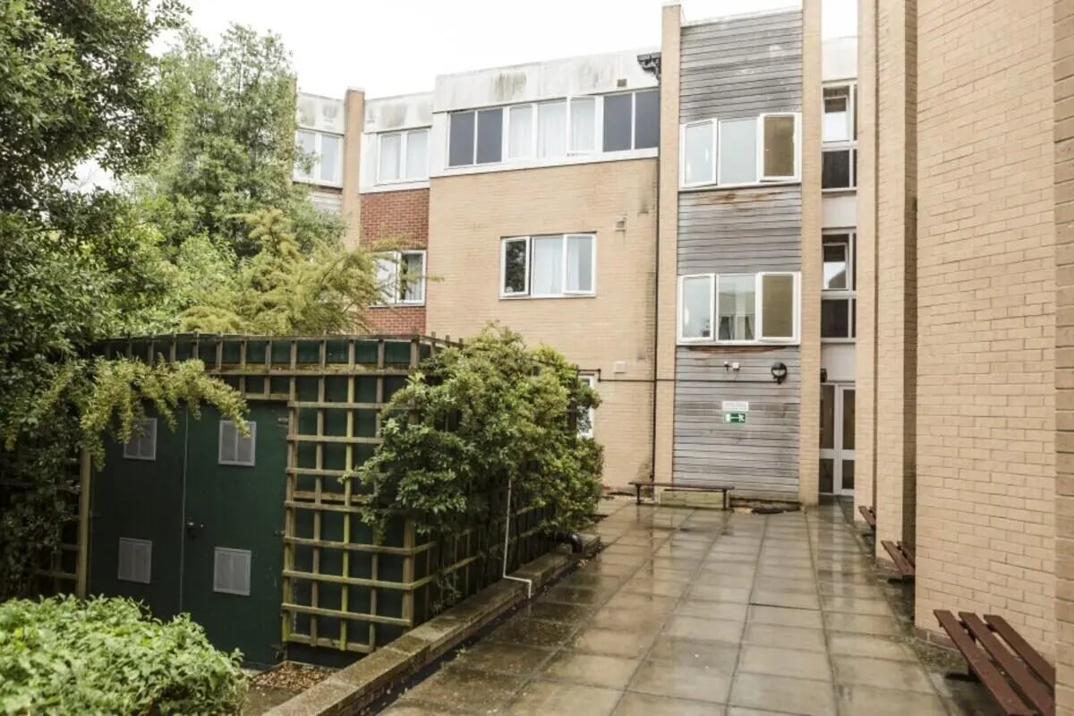 Green shed and building exterior with benches exterior at Okeford House in Bournemouth Student Accommodation
