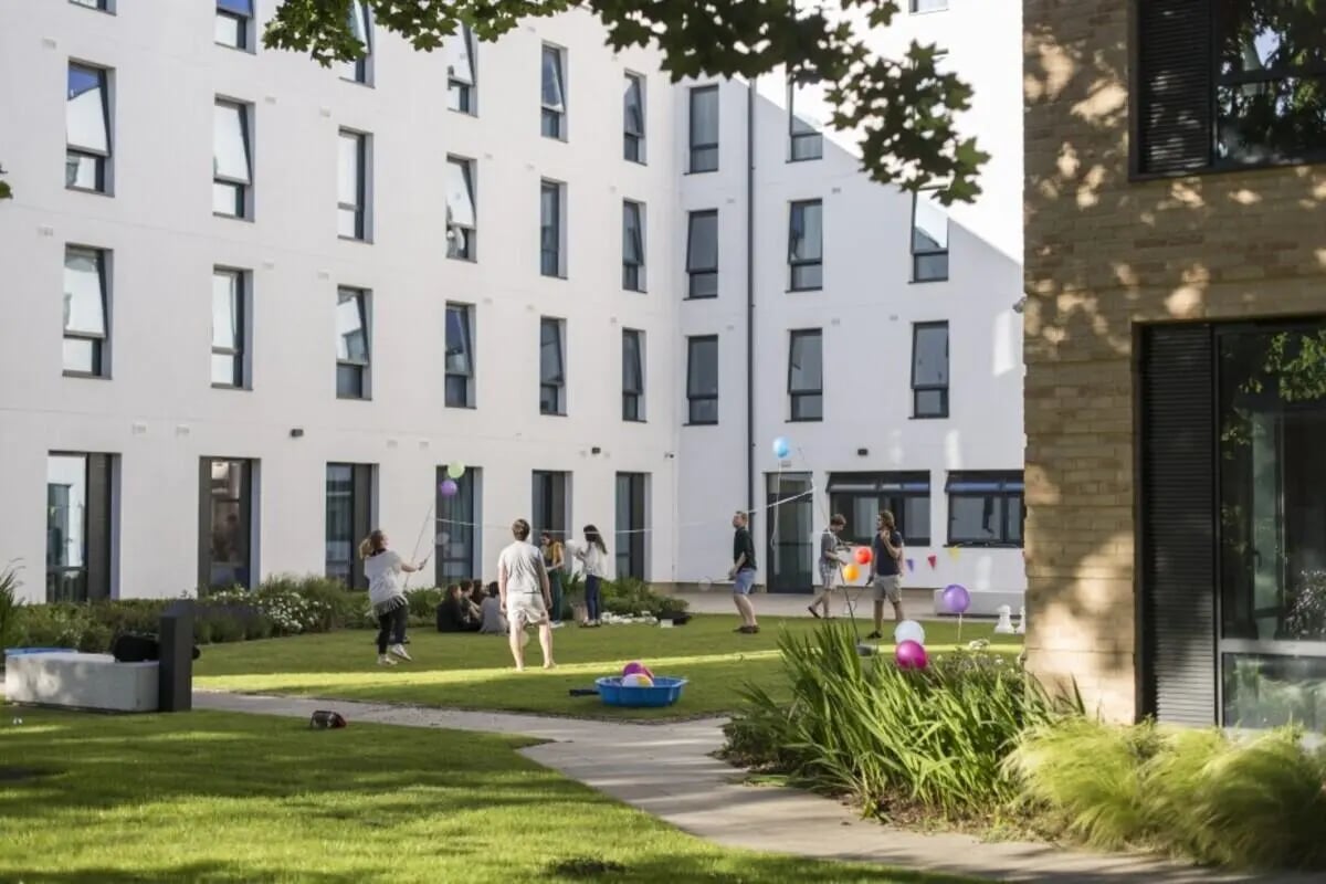 Students playing in courtyard outside accommodation exterior at Prince Consort Village in London Student Accommodation