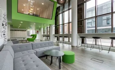 Modern lounge with sofas bar stools and tables common area at Glendower House in Cardiff Student Accommodation