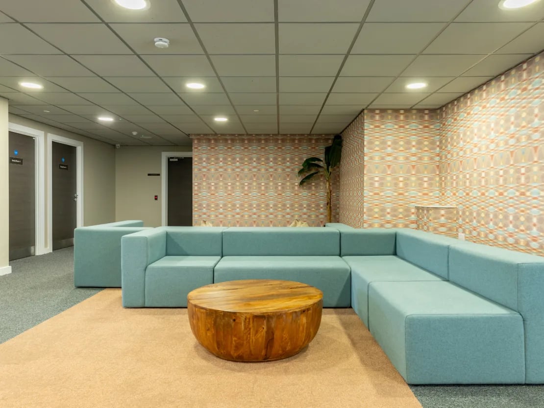 Blue sectional sofa wooden coffee table living room at Radford Mill in Nottingham Student Accommodation