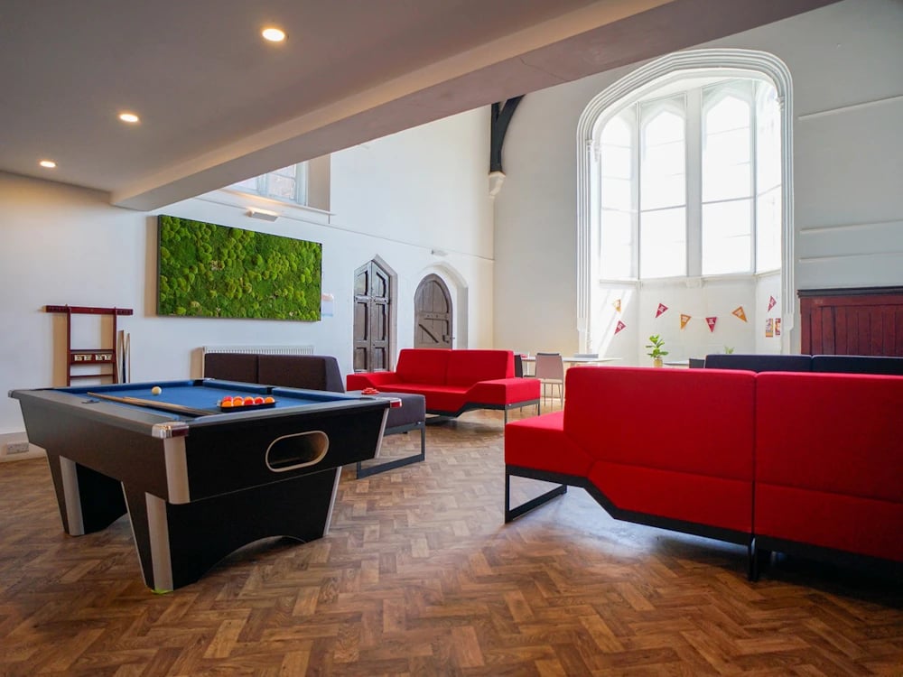 Pool table red couches green wall art living room at Orme House in Newcastle Under Lyme Student Accommodation