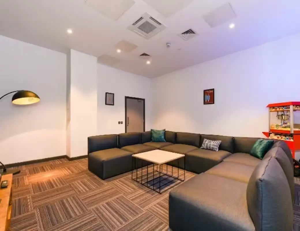 Large sectional sofa with coffee table and popcorn machine living room at Swanston House in Belfast Student Accommodation