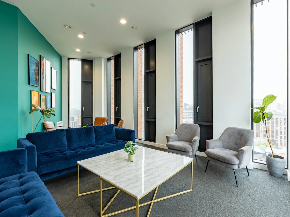 Blue sofa marble table grey armchairs living room at Straits Village in Nottingham Student Accommodation