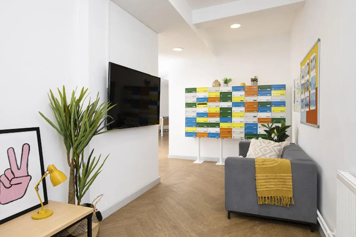 Sofa with blanket and colourful mailboxes living area at Lakeside in Birmingham Student Accommodation
