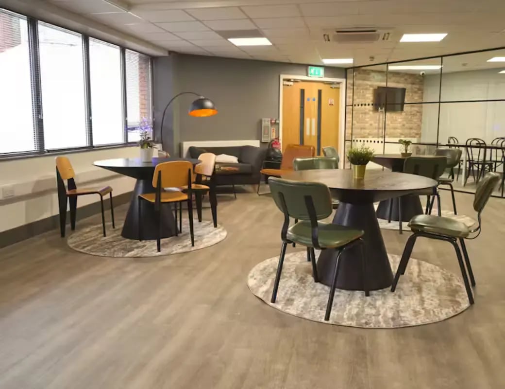 Round tables chairs and sofa common area living room at Hydrogen in Nottingham Student Accommodation