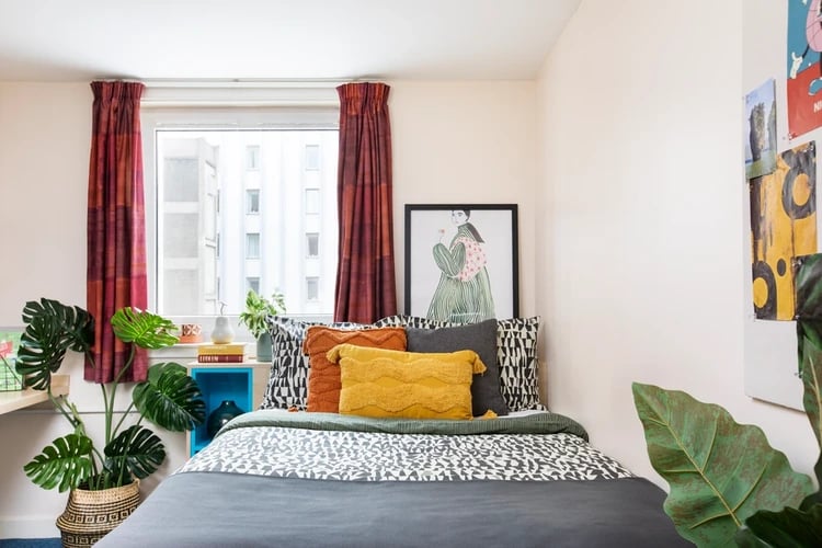 Bed with patterned bedding artwork and plant bedroom at Merchant City House in Glasgow Student Accommodation