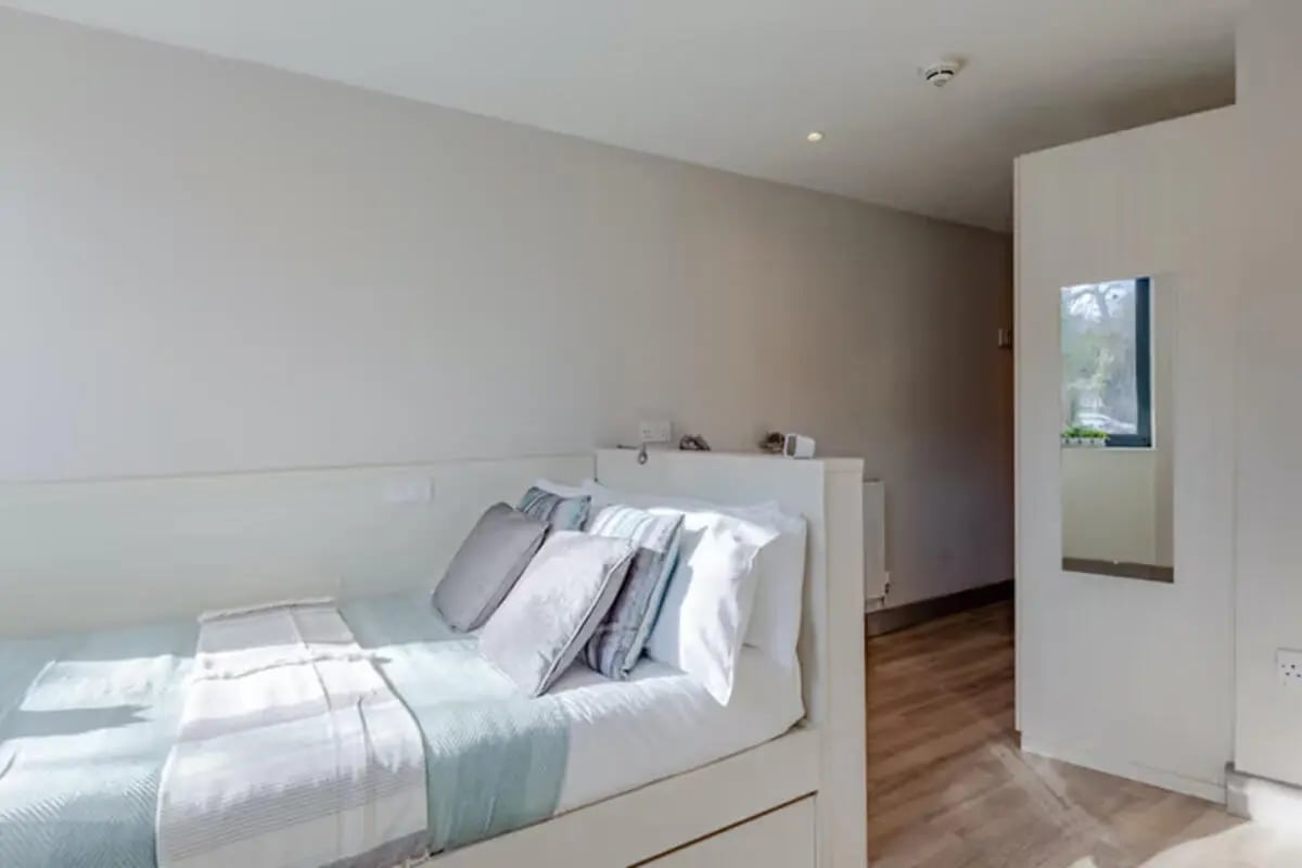 Bed with pillows and blankets wooden floor bedroom at Mercury House in Bournemouth Student Accommodation
