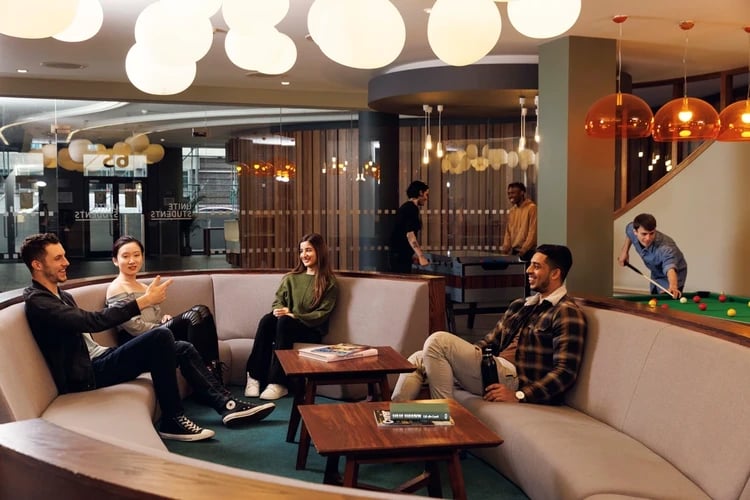Students relaxing and playing pool living room at Drapery Place in London Student Accommodation