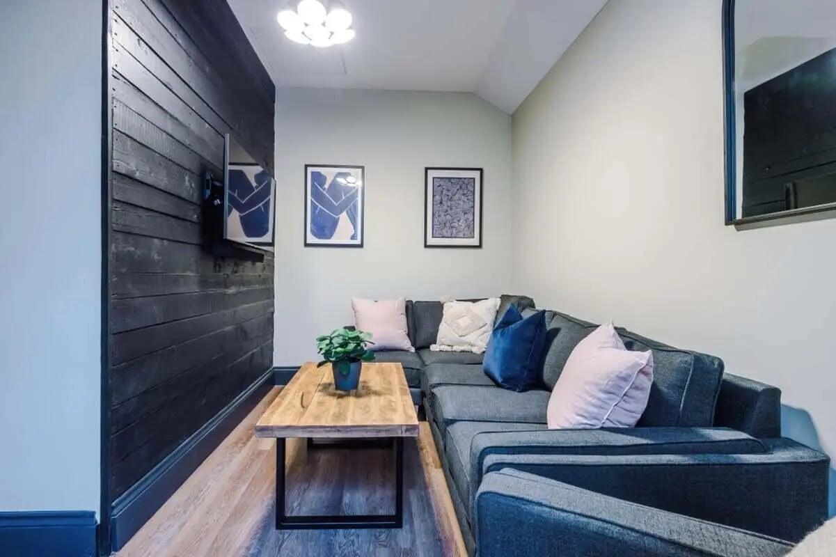 Sectional sofa wooden table plant living room at The Hosiery in Leicester Student Accommodation