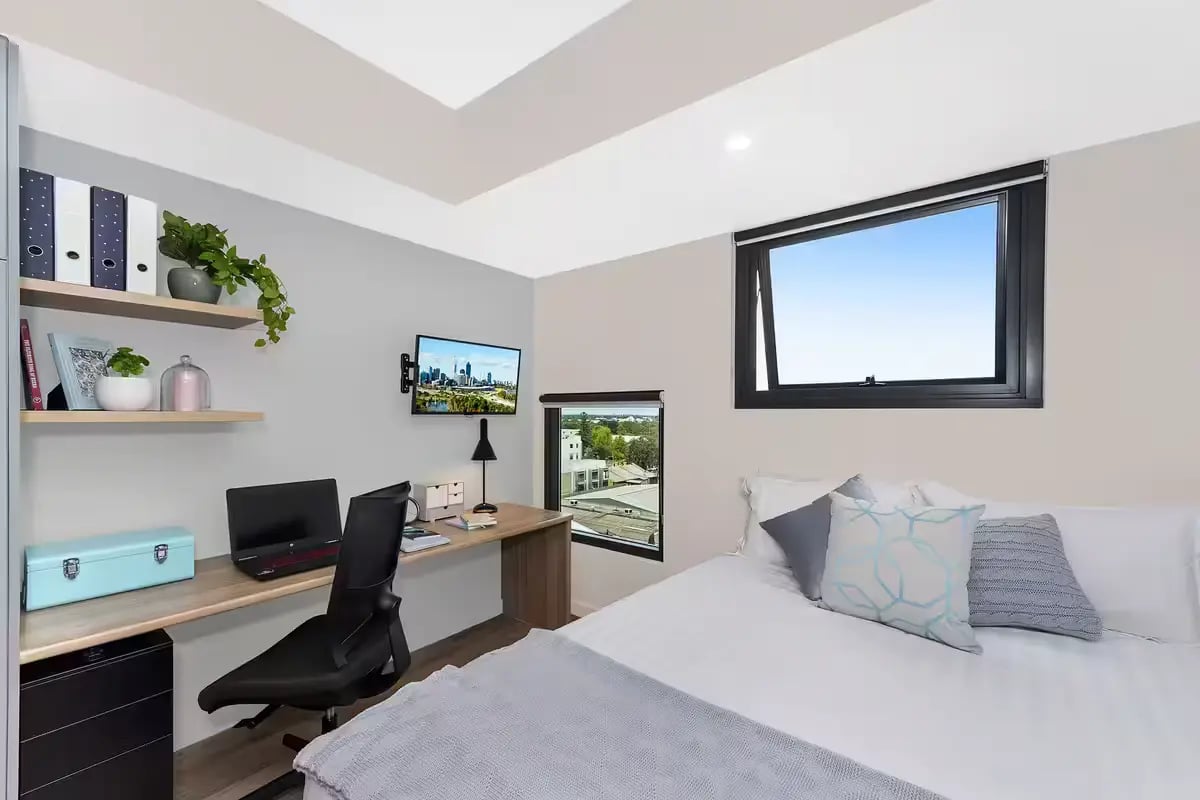 Bed desk shelves laptop computer TV bedroom at Scape Waymouth in Adelaide Student Accommodation
