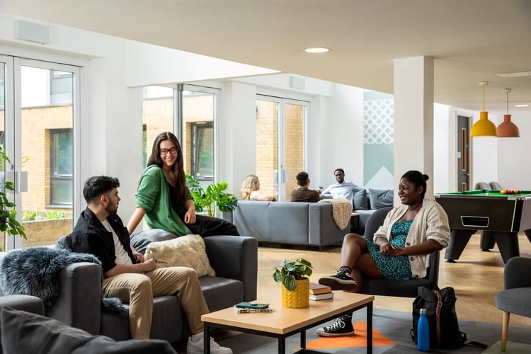 Students relaxing on sofas by pool table living room at Beech House in Oxford Student Accommodation