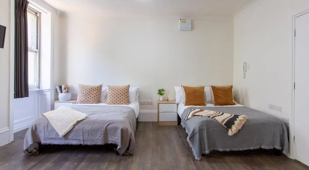 Two beds with pillows and blankets bedroom at Bloomsbury Janet Poole House in London Student Accommodation