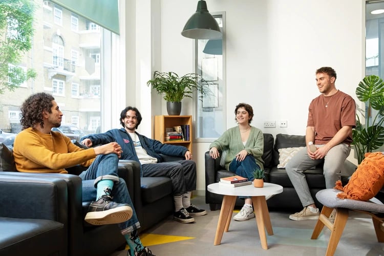 Four students relaxing on sofas in a common room at Somerset Court in London Student Accommodation
