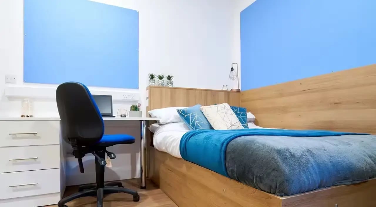 Bed desk chair laptop succulents blue decor bedroom at St Leonard's House in Lancaster Student Accommodation