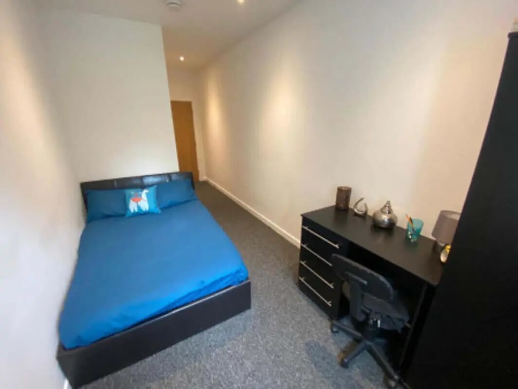 Blue bed and black desk study area at St Mary's House Sheffield in Sheffield Student Accommodation