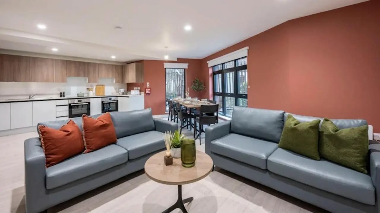 Two grey sofas dining table kitchen area living room at Raffles Hall in York Student Accommodation
