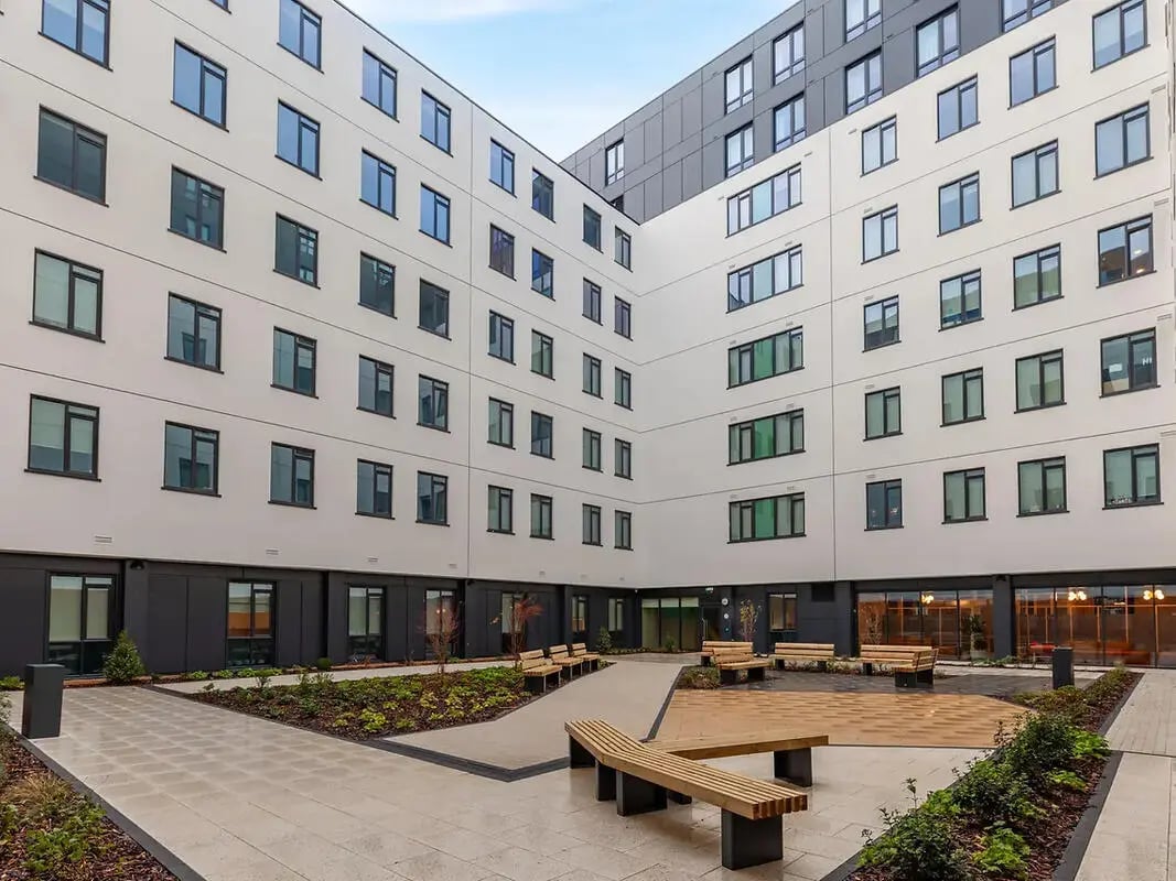 Courtyard with benches and modern building exterior. at Yugo St. Crispin's House in Norwich Student Accommodation
