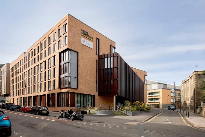Modern brick building with cars parked exterior at Campbell House in Bristol Student Accommodation