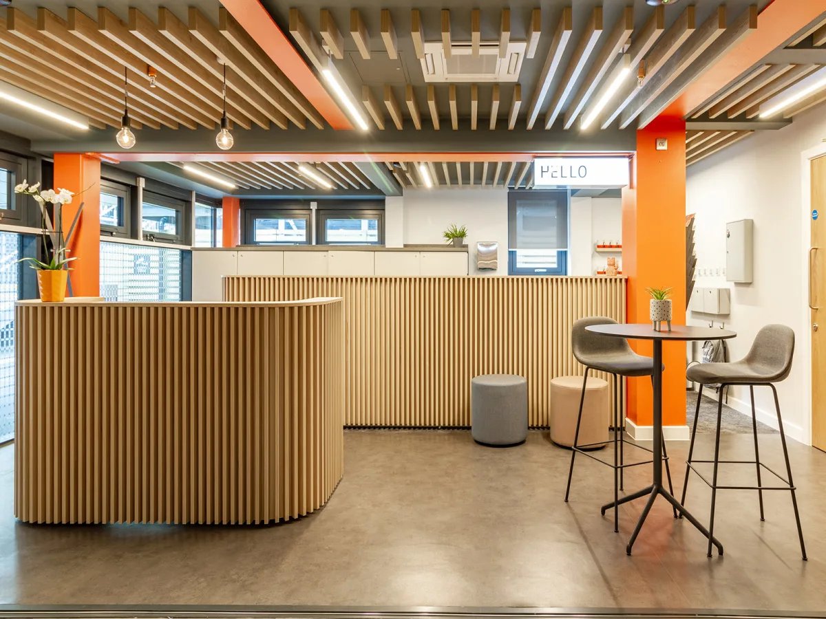 Reception desk with stools and chairs common area at The Refinery in Leeds Student Accommodation