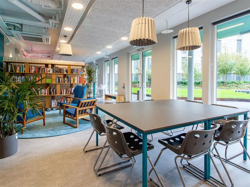 Bookshelves chairs and table communal area at Benedict's Gate in Norwich Student Accommodation