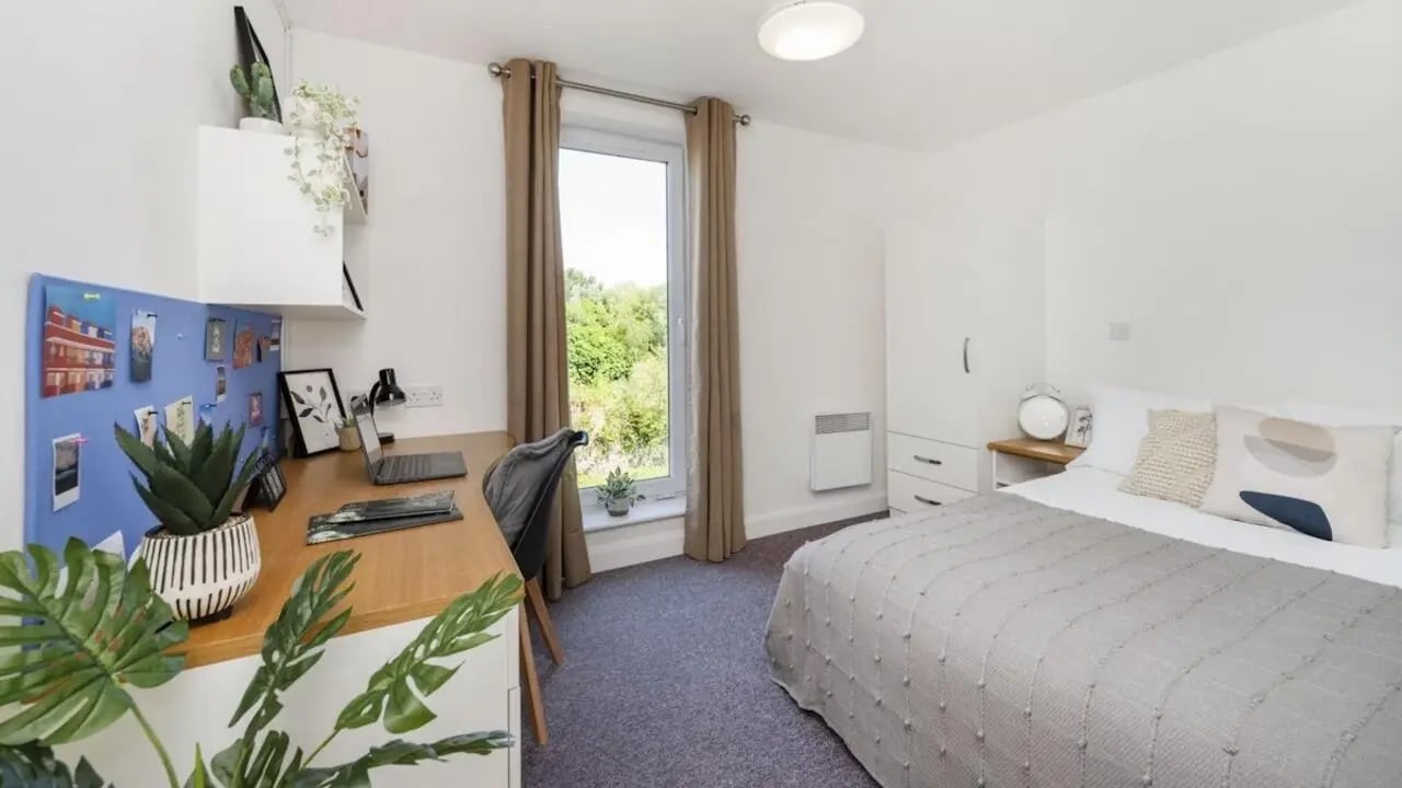 Desk plants bulletin board bed wardrobe bedroom at Riverside House - Manchester in Salford Student Accommodation