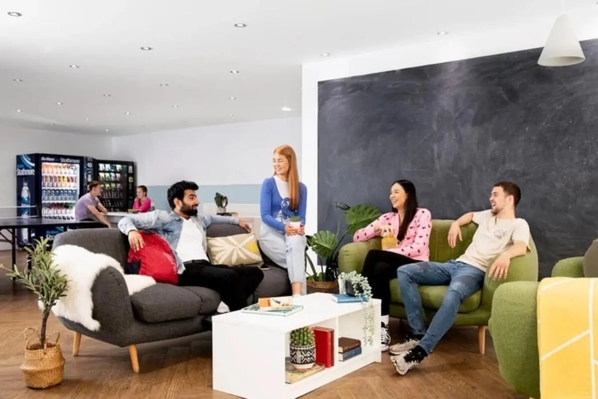 Students relaxing on sofas near vending machines living area at Kelvin Court in Glasgow Student Accommodation