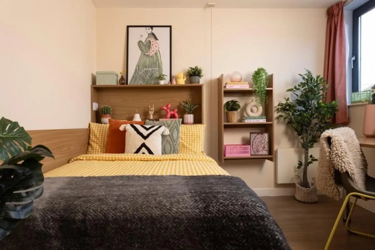 Bed with yellow bedding and artwork Bedroom at Thurso Street in Glasgow Student Accommodation