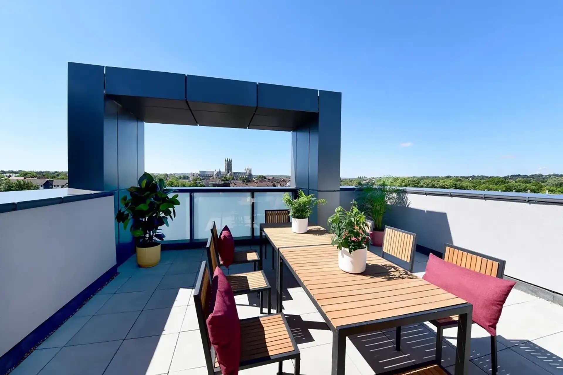 Dining table chairs plants on rooftop exterior at Riverside  in Canterbury Student Accommodation