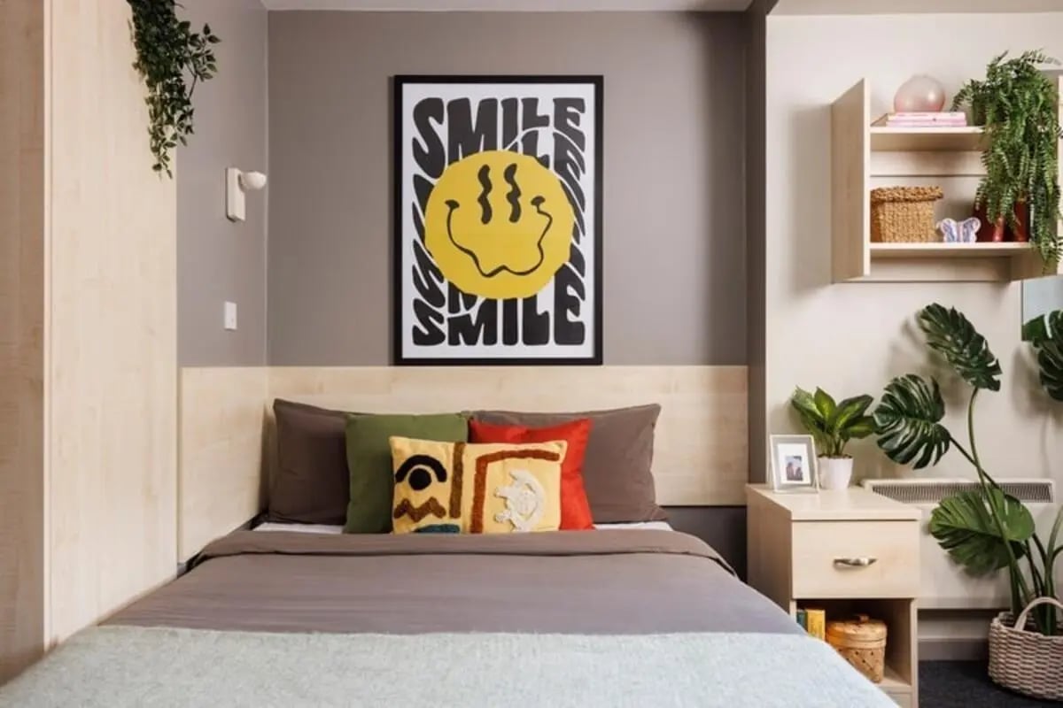 Bed pillows poster plants nightstand bedroom at The Tannery Leeds in Leeds Student Accommodation