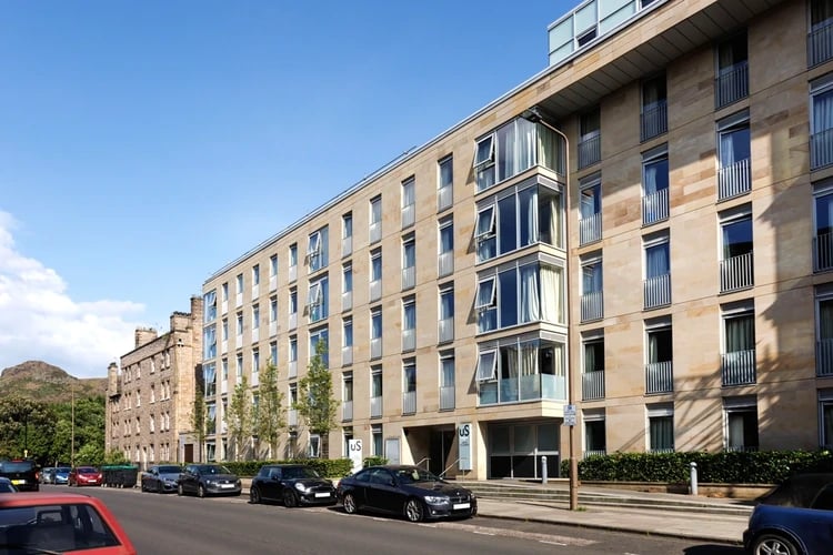 Modern stone student accommodation building with cars exterior at The Old Printworks in Edinburgh Student Accommodation