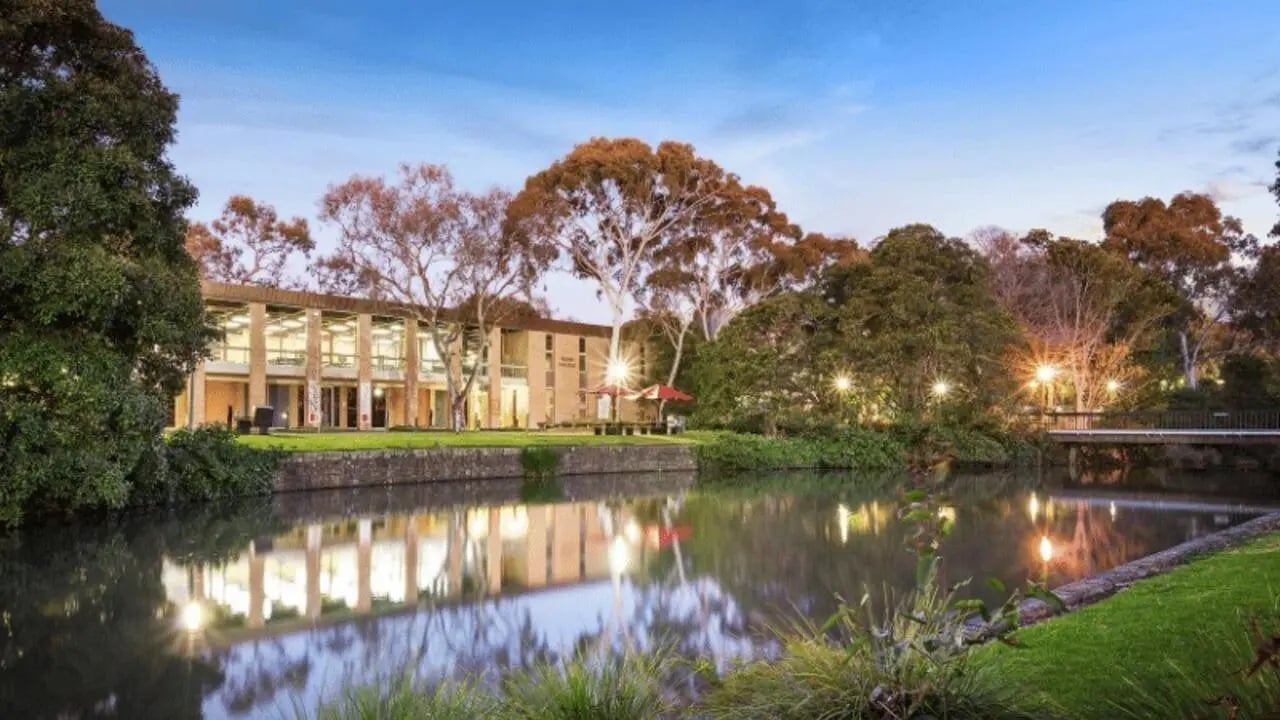 Building by water with trees and bridge Exterior at La Trobe University - Glenn College in Melbourne Student Accommodation