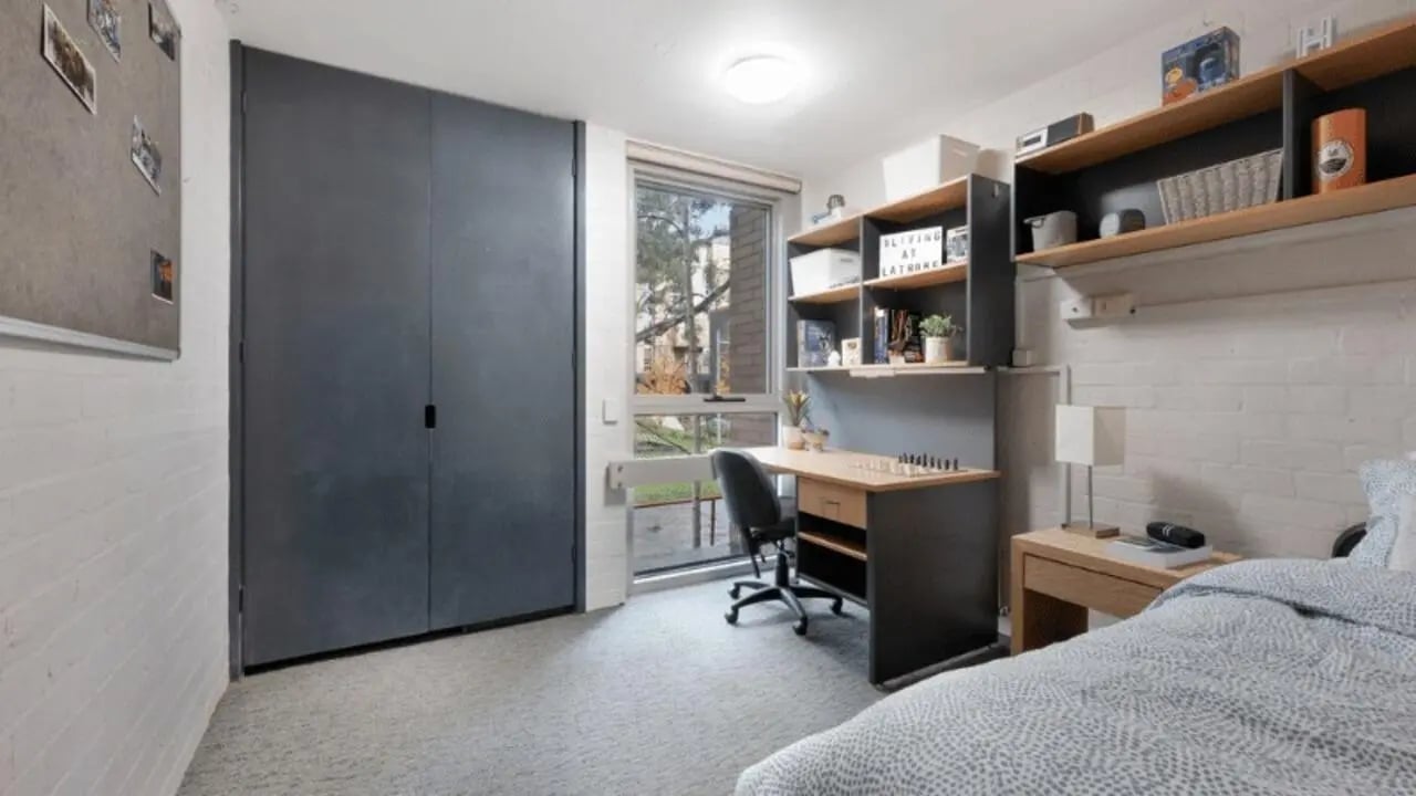 Wardrobe desk shelves bedside table bed bedroom at La Trobe University - Menzies College in Melbourne Student Accommodation